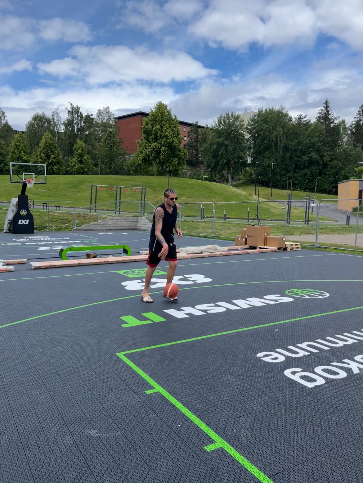 Spiller dribler ballen på en utendørs 3x3-bane i resirkulert plast fra Play IT.
