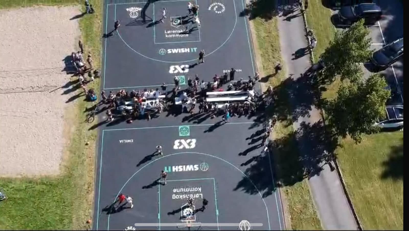 Dronebilde av to 3x3-baner fra Play IT med folk samlet under et arrangement.